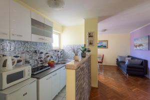 eine Küche und ein Wohnzimmer mit einem Sofa und einer Mikrowelle in der Unterkunft Spacious City Center apartment - 4 pax in Dubrovnik
