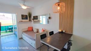 1 dormitorio con cama, mesa y escritorio en Mareverde apartment with pools and bar - Fanabe beach, en Adeje