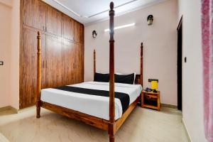 1 dormitorio con 1 cama y armario de madera en OYO Hotel Salasar Heritage, en Jaipur