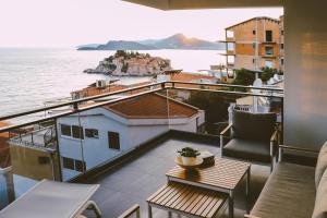 a balcony with a table and a view of the water at Sveti Stefan Presidential Sea view Resort in Sveti Stefan