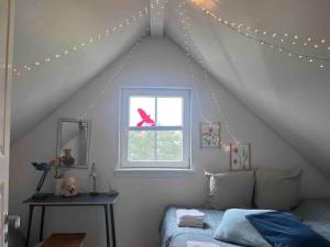 a bedroom with a bed and a window with lights at Hyggeligt sommerhus tæt på vandet i Bro Strand in Brenderup