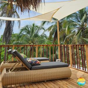 eine Terrasse mit einem Stuhl und einem Sonnenschirm in der Unterkunft Natyva House in Guachaca