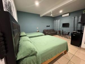 a bedroom with two beds and a living room at Loft Brisa Del Mar #9 in Brisas de Zicatela