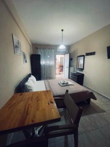 a room with a bed and a wooden table at Klapidis apartments in Kriopigi