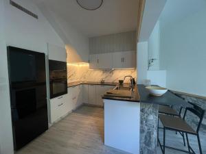 a kitchen with a black refrigerator and white cabinets at Casa do Sol in O Grove