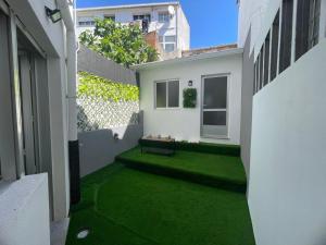 a small courtyard with green grass in a building at Casa do Sol in O Grove