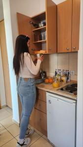 Uma mulher na cozinha a preparar comida. em Bela kuća studio apartments-Na korak do mora-A step to the sea em Rafailovici