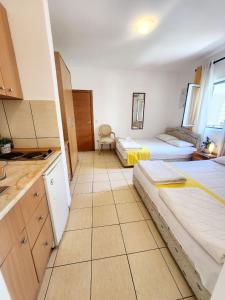 um quarto amplo com 2 camas e uma cozinha em Bela kuća studio apartments-Na korak do mora-A step to the sea em Rafailovici