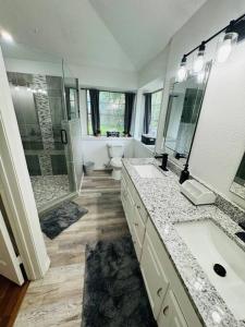 Un baño con dos lavabos y una ducha y un inodoro. en Little House in the Prairie, en Grand Prairie 9 fotos más