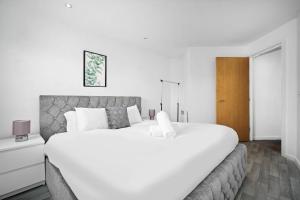 a bedroom with a large white bed and a wooden door at 2 Bedroom Apartment With Balcony - FREE PARKING in Birmingham +34 photos