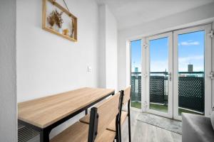 a dining room with a table and a large window at 2 Bedroom Apartment With Balcony - FREE PARKING in Birmingham