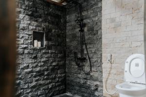a bathroom with a shower in a brick wall at D'Ume Bendoel Homestay in Jatiluwih