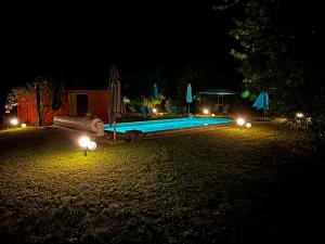 una piscina por la noche con luces en un patio en Domaine Plan des Devens, en Roussillon