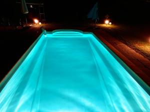 ein Pool in der Nacht mit blauen Lichtern in der Unterkunft Domaine Plan des Devens in Roussillon