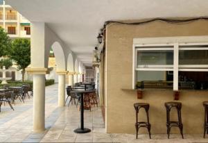 an outdoor patio with chairs and tables and a building at ESTUDIO Torrevieja P & A in La Mata