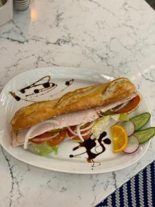 a sandwich on a plate with pickles and an orange slice at Hollywood Hotel in Los Angeles