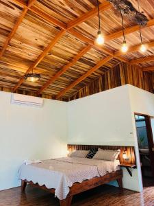 een bed in een kamer met een houten plafond bij Ficus house in Boca Tapada