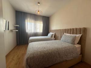1 dormitorio con 2 camas y ventana en AeroChic en Nouaceur