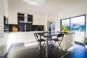 a kitchen with white cabinets and a table and chairs at Cristy's Place in Cabouco