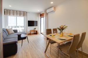 a living room with a table and a couch at Unique 1BD Ocean View AC Wi-Fi Beach 100m in Armação de Pêra