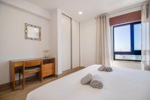 a bedroom with a bed and a desk and a window at Unique 1BD Ocean View AC Wi-Fi Beach 100m in Armação de Pêra