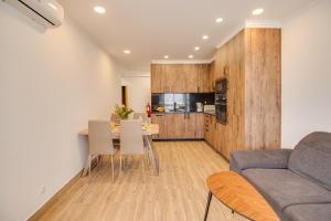 a living room and kitchen with a couch and a table at Unique 1BD Ocean View AC Wi-Fi Beach 100m in Armação de Pêra