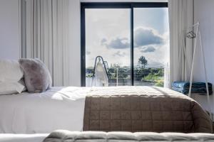 a bedroom with a bed and a large window at Cristy's Place in Cabouco +14 photos