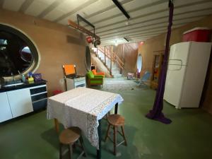 a kitchen with a table and a refrigerator in a room at Chalés Sitio Mangala in Itapeva