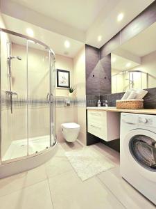 ein Bad mit einer Dusche, einem WC und einer Waschmaschine in der Unterkunft Apartament Nice View -16piętro, parking podziemny, blisko morza in Danzig