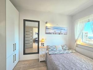 Schlafzimmer mit einem Bett und einem Spiegel in der Unterkunft Apartament Nice View -16piętro, parking podziemny, blisko morza in Danzig