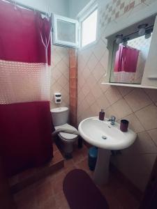 a bathroom with a white sink and a toilet at Klapidis apartments in Kriopigi +114 photos