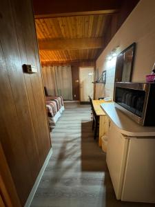 a room with a kitchen with a microwave and a table at Ace Crown Motel in Medicine Hat