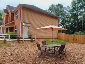 a table and chairs with an umbrella in front of a house at Nice Luxury Suite in Brenda View