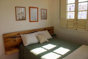 a bedroom with a bed with a wooden headboard and a window at Grimpa Hospedagem Urubici in Urubici