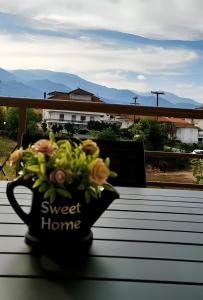 a black mug with a bouquet of flowers on a table at AVELLANA LUXURY SUITES in Leptokarya