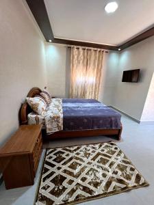 a bedroom with a large bed and a rug at Appartements ELKHAIR in Tahannout