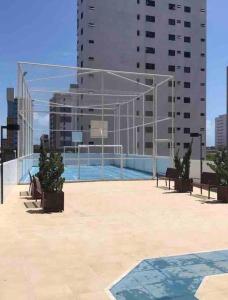 a building with a swimming pool in a city at Apartamento Dimensional Home Service - Manaíra in João Pessoa