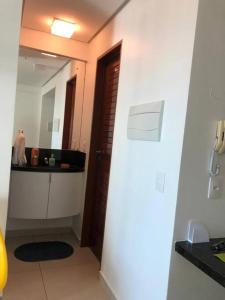 a bathroom with a sink and a mirror in a room at Apartamento Dimensional Home Service - Manaíra in João Pessoa