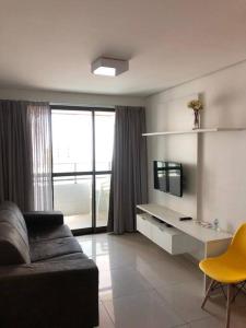 a living room with a couch and a desk at Apartamento Dimensional Home Service - Manaíra in João Pessoa +22 photos