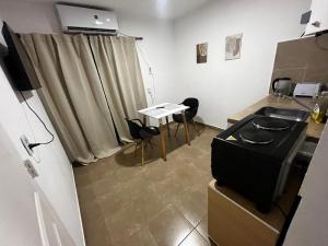 a room with a kitchen with a table and chairs at hospedaje LH primero E a 15 minutos del aeropuerto ezeiza in Ezeiza