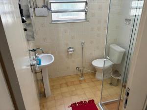 ein Bad mit einer Dusche, einem WC und einem Waschbecken in der Unterkunft SUITES VISTA MAR AZUL in Saquarema