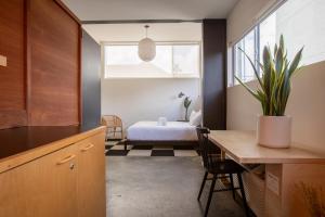 een keuken met een tafel en een slaapkamer met een bed bij Abpopa Hillcrest in San Diego