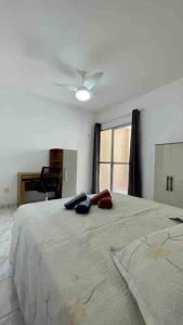 une chambre avec un grand lit avec un ventilateur de plafond dans l'établissement Apartamento super aconchegante a 250 mts da Praia, à Guarapari