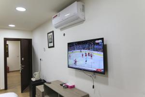 a tv on a wall with a hockey game on it at Sindyan Resort in Amman