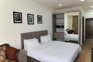 a bedroom with a large white bed and a mirror at Sindyan Resort in Amman