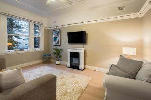 a living room with a tv and a fireplace at Best location in Manly Harbour view in Sydney