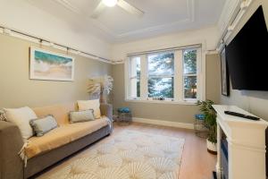 sala de estar con sofá y TV de pantalla plana en Best location in Manly Harbour view en Sídney