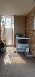 una TV seduta in una stanza con un muro di mattoni di Casa Térrea-Bertioga-Uso exclusivo para de 1 a 12 pessoas a Bertioga