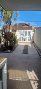 un patio con una recinzione bianca e palme di Casa Térrea-Bertioga-Uso exclusivo para de 1 a 12 pessoas a Bertioga