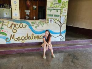 een vrouw die op de trappen van een gebouw zit bij Finca Magdalena Eco Lodge in Balgue